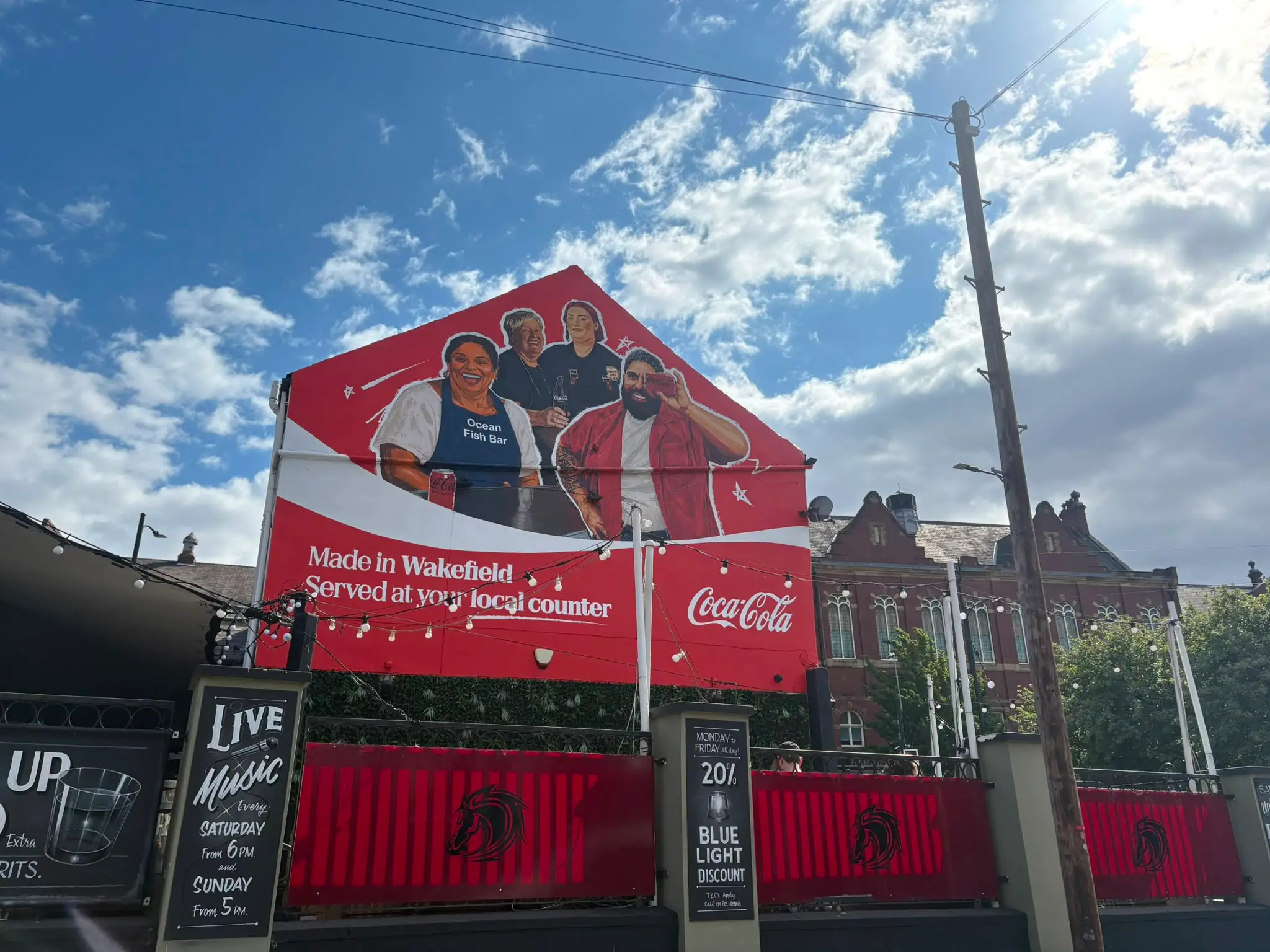The completed hand-painted Coca-Cola mural, following the coordinated removal of the commercial scaffolding.